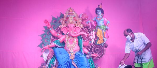 A Hindu devotee wearing a protective mask sanitizes a pandal or a temporary platform, next to an idol of Hindu god Ganesh, the deity of prosperity, ahead of the Ganesh Chaturthi festival, amidst the coronavirus disease (COVID-19) outbreak, in Kolkata, India, August 19, 2020. REUTERS/Rupak De Chowdhuri     TPX IMAGES OF THE DAY - Sputnik International
