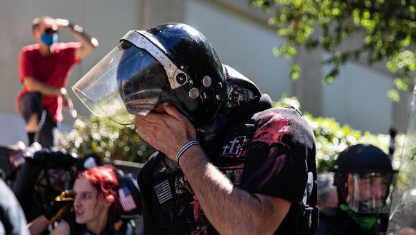 Alan Swinney wipes his face after being hit with pepper spray during clashes at a protest against police brutality and racial injustice in Portland, Oregon, U.S., August 22, 2020.  - Sputnik International