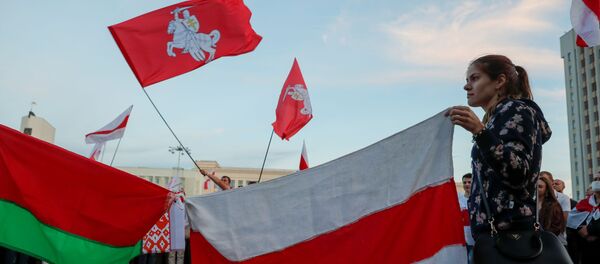 A woman holds a historical white-red-white flag of Belarus during an opposition demonstration against presidential election results at the Independence Square in Minsk, Belarus August 22, 2020. - Sputnik International