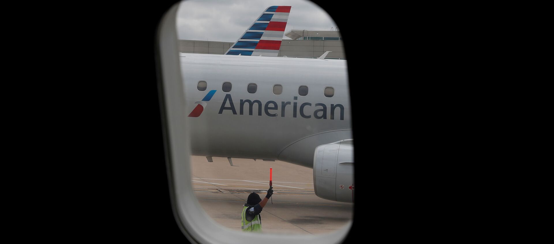 FILE PHOTO: An airlines worker signals next to an American Airlines plane that arrived at Hartsfield–Jackson Atlanta International Airport, as the coronavirus disease (COVID-19) continues, in Atlanta, Georgia, U.S., May 19, 2020. REUTERS/Shannon Stapleton/File Photo - Sputnik International, 1920, 24.08.2020