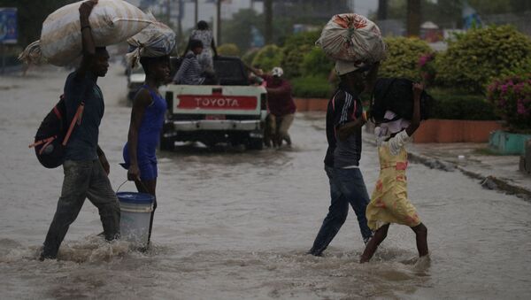 People cross a flooded street during the passage of Tropical Storm Laura, in Port-au-Prince, Haiti August 23, 2020. - Sputnik International