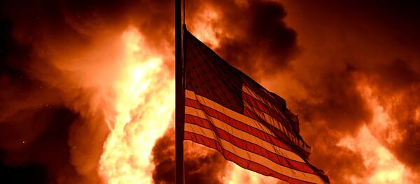 Flames engulf the Community Corrections Division building as an American flag flutters on a pole in an arson attack after a black man identified as Jacob Blake, was shot several times by police in Kenosha, Wisconsin, 24 August 2020. Flames engulf the Community Corrections Division building as an American flag flutters on a pole in an arson attack after a black man identified as Jacob Blake, was shot several times by police in Kenosha, Wisconsin, 24 August 2020. - Sputnik International