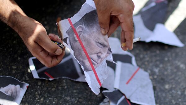 A Palestinian demonstrator burns a picture depicting U.S. President Donald Trump during a protest against the United Arab Emirates' deal with Israel to normalise relations, in Gaza City August 19, 2020 - Sputnik International