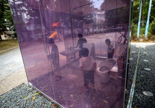 Children try out the transparent public toilet that becomes opaque when occupied, designed by Japanese architect Shigeru Ban, at Yoyogi Fukamachi Mini Park in Tokyo, Japan August 26, 2020 - Sputnik International