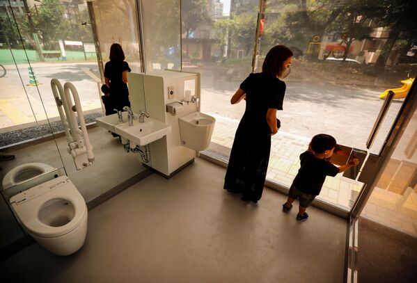 A mother and her son check out the transparent public toilet that becomes opaque when occupied, designed by Japanese architect Shigeru Ban, at Yoyogi Fukamachi Mini Park in Tokyo, Japan August 26, 2020 - Sputnik International
