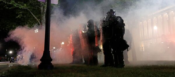 Law enforcement officers guard during a protest following the police shooting of Jacob Blake, a Black man, in Kenosha, Wisconsin, U.S. August 25, 2020 - Sputnik International