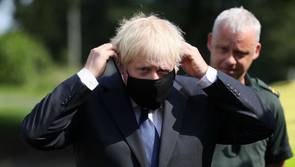 Britain's Prime Minister Boris Johnson puts on a mask at the Northern Ireland Ambulance Service HQ during his visit to Belfast, Northern Ireland August 13, 2020.  - Sputnik International
