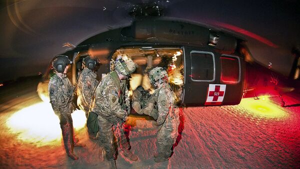 Army medics unload a mock casualty from a UH-60 Black Hawk medevac helicopter during a training exercise at the Joint Readiness Training Center on Fort Polk, La., Jan. 23, 2012. - Sputnik International
