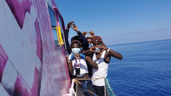 In this undated handout photo people pose for a photo after being rescued by the Louise Michel, a migrants search and rescue ship operating in the Mediterranean and financed by British street artist Banksy, at sea. - Sputnik International