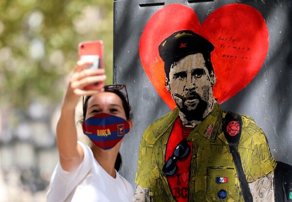 A woman takes a selfie with a mural of Lionel Messi dressed as Che Guevara as FC Barcelona's squad arrive for coronavirus disease (COVID-19) test, ahead of the resumption of training on August 31, in Barcelona, Spain August 30, 2020. - Sputnik International
