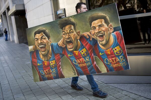 A man carries a painting representing Spanish Barcelona's Uruguayan forward Luis Suarez (L), Barcelona's Brazilian forward Neymar and Barcelona's Argentinian forward Lionel Messi (R) painted by Spanish cartoonist Vizcarra to the presentation of the 12th edition of the book entitled Relats solidaris de l'esport (Stories of solidarity in sport) in Barcelona on February 17, 2017.  - Sputnik International