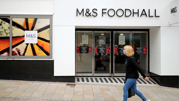 A woman wearing a protective face mask walks outside a Marks and Spencer (M&S) store, amid the outbreak of the coronavirus disease (COVID-19), in Altrincham, Britain August 27, 2020. - Sputnik International