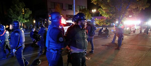 Police officers detain a demonstrator during a protest against police violence and racial injustice in Portland, Oregon, U.S., August 24, 2020.   - Sputnik International