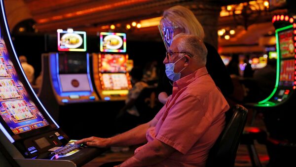 People wearing protective face masks play slot machines amid the coronavirus disease (COVID-19) outbreak, at a casino outside the French Quarter in New Orleans, Louisiana, U.S. August 30, 2020. - Sputnik International