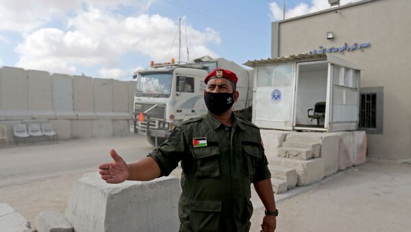 A Palestinian member of Hamas security forces stands outside the main commercial crossing with Gaza, Kerem Shalom, in the southern Gaza strip August 11, 2020.  - Sputnik International