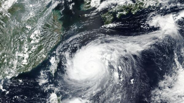 This Monday, Aug. 31, 2020, satellite image released by NASA shows Typhoon Maysak over Japan's southernmost islands, including Okinawa, center. The powerful typhoon was blowing over Japan's southernmost islands early Tuesday on course for Japan's main southern island and later the Korean Peninsula. Warnings issued for the area around Okinawa, home to U.S. military bases, said strong gusts could cause some homes to collapse and extremely high tides were a risk as well. - Sputnik International