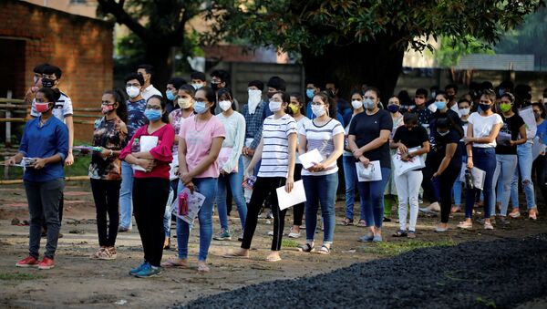 Students wearing protective face masks wait to enter an examination centre for Joint Entrance Examination (JEE), amidst the spread of the coronavirus disease (COVID-19), in Ahmedabad, India, September 1, 2020 - Sputnik International