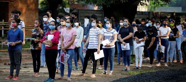 Students wearing protective face masks wait to enter an examination centre for Joint Entrance Examination (JEE), amidst the spread of the coronavirus disease (COVID-19), in Ahmedabad, India, September 1, 2020 - Sputnik International