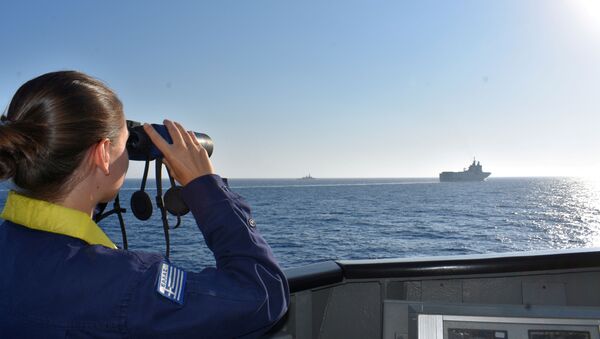 A woman looks through binoculars as Greek and French vessels sail in formation during a joint military exercise in Mediterranean sea, in this undated handout image - Sputnik International