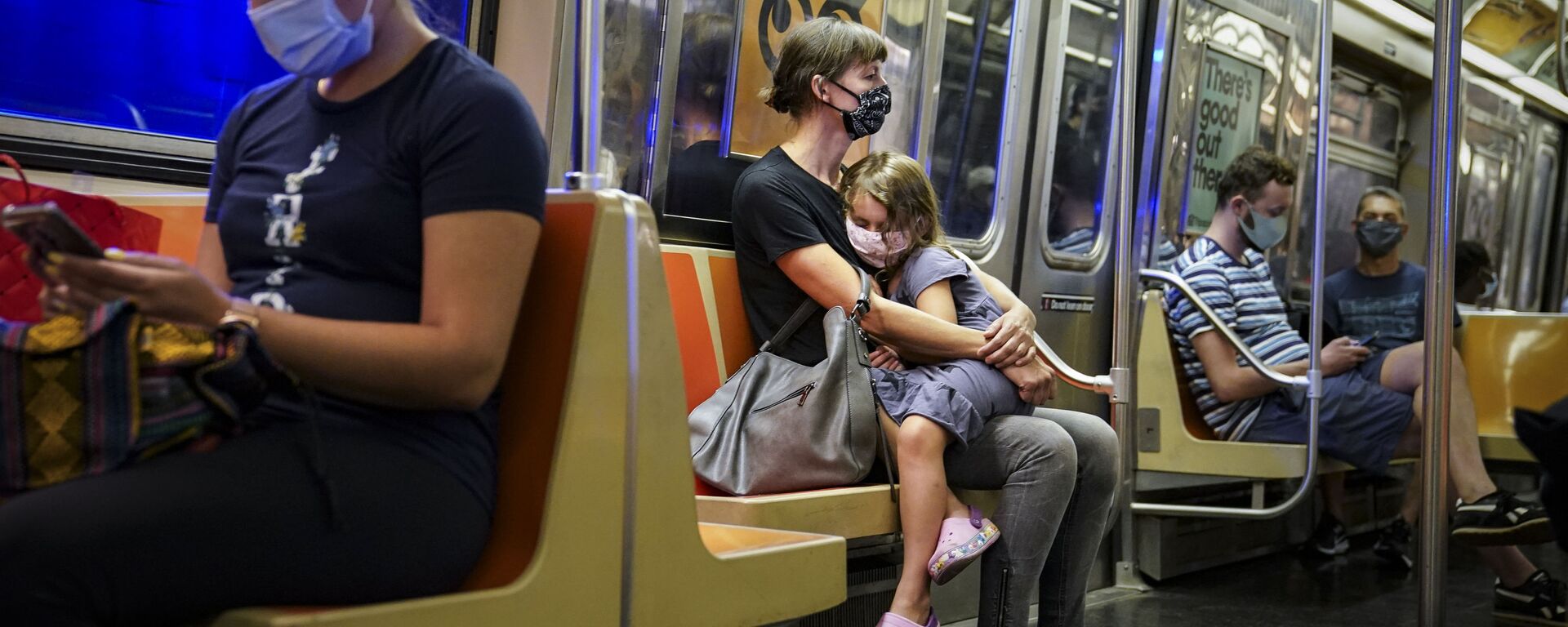 A child rests on a subway car while riders wear protective masks due to COVID-19 concerns, Monday, Aug. 17, 2020, in New York. - Sputnik International, 1920, 04.05.2022