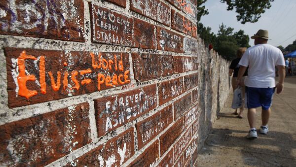 People walk by the wall filled with inscriptions outside the Graceland Mansion, Elvis Presley's home in Memphis, Tennessee, 14 August 2007 - Sputnik International