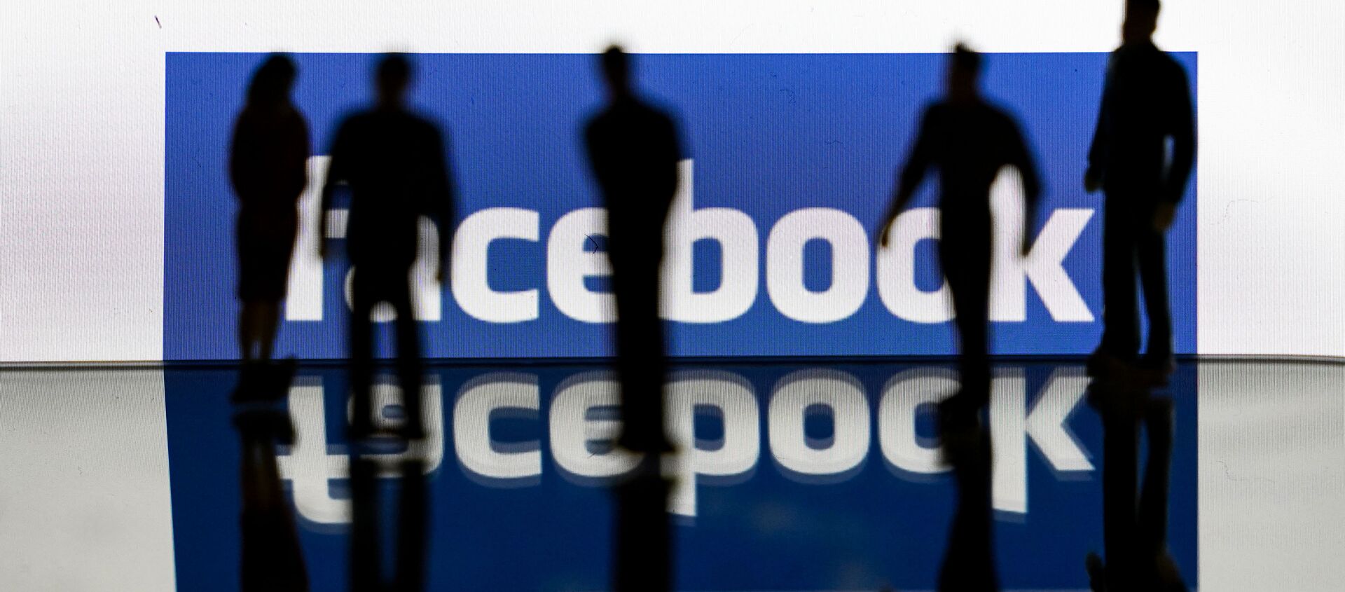 (FILES) In this file photo taken on February 14, 2020 silhouettes are seen in front of the logo of US social media Facebook in Brussels - Sputnik International, 1920, 02.09.2020