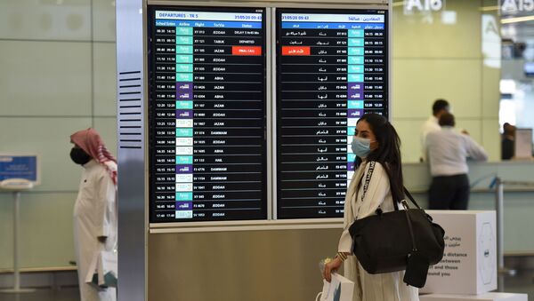 A Saudi passenger, wearing a protective face mask, arrives at terminal 5 in the King Fahad International Airport, designated for domestic flights, in the capital Riyadh on May 31, 2020, after authorities lifted the ban on flights within the country. - Sputnik International