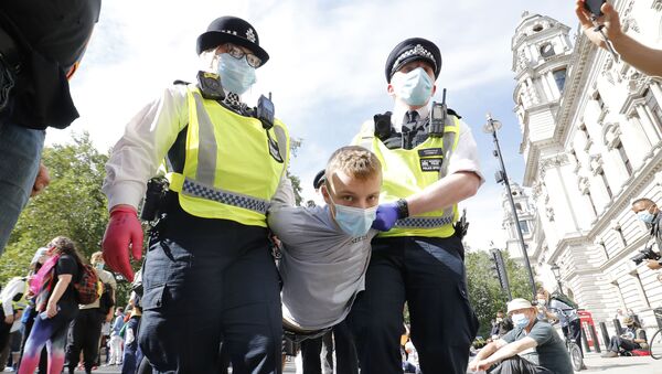 Police officers wearing face masks and gloves due to the COVID-19 pandemic, detain an activist from the climate protest group Extinction Rebellion as they demonstrate in Parliament Square in London on September 2, 2020, on the second day of their new season of mass rebellions. - Sputnik International
