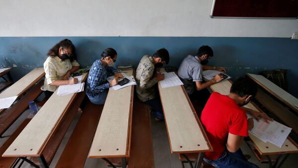 Students wearing protective face masks take a Gujarat Common Entrance Test (GUJCET) while maintaining social distance amidst the coronavirus disease (COVID-19) outbreak, inside a classroom in Ahmedabad, India, August 24, 2020 - Sputnik International