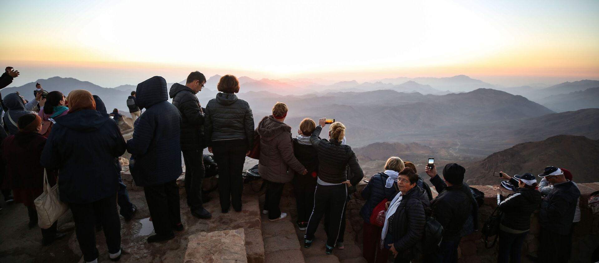 Tourists stand to watch the sunrise after scaling Mount Catherine, above the 6th-century Greek Orthodox Christian monastery of Saint Catherine, near the Egyptian town of the same name in south of the Sinai peninsula, on October 19, 2018, as part of an inter-religious peace conference under slogan Here We pray together.  - Sputnik International, 1920, 03.09.2020