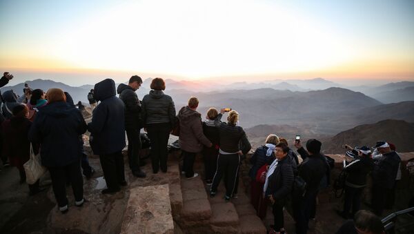 Tourists stand to watch the sunrise after scaling Mount Catherine, above the 6th-century Greek Orthodox Christian monastery of Saint Catherine, near the Egyptian town of the same name in south of the Sinai peninsula, on October 19, 2018, as part of an inter-religious peace conference under slogan Here We pray together.  - Sputnik International