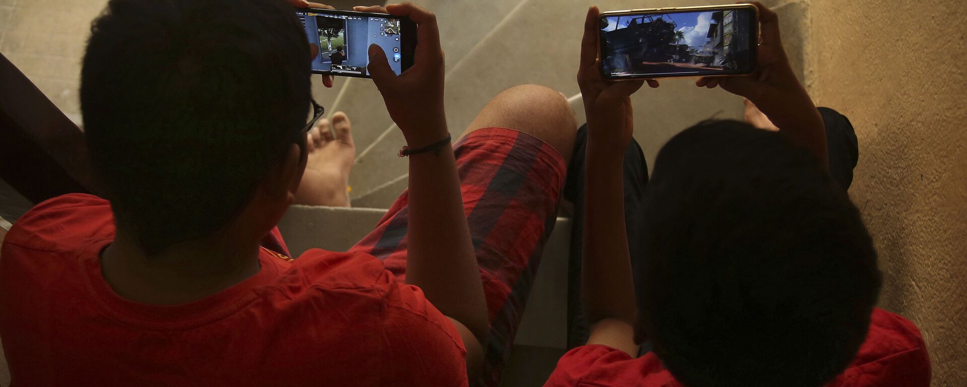 Indian children play online game PUBG on their mobile phones sitting on stairs outside their house  in Hyderabad, India, Friday, April 5, 2019.  - Sputnik International, 1920, 08.09.2020
