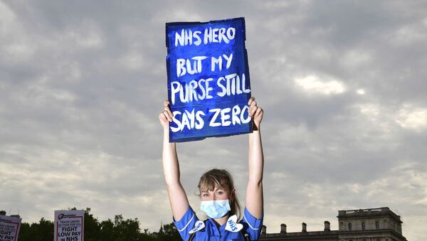 National Health Service (NHS) worker poses with a placard, during a demonstration as part of a national protest over pay, in London, Saturday Aug. 8, 2020.  - Sputnik International