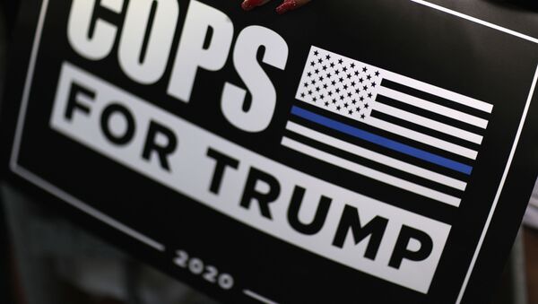 A supporter holds a Cops for Trump sign as U.S. President Donald Trump delivers a campaign speech at Arnold Palmer Regional Airport in Latrobe, Pennsylvania, U.S., September 3, 2020 - Sputnik International