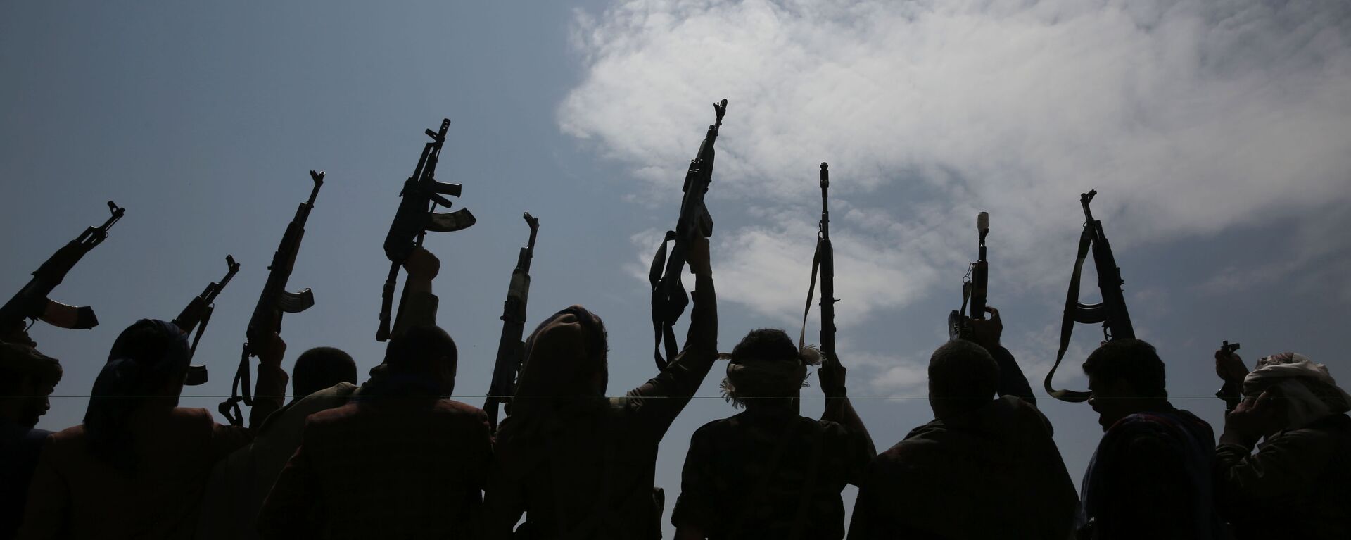 A silhouette of tribesmen loyal to Houthi rebels raise their weapons as they chant slogans during a gathering against the agreement to establish diplomatic relations between Israel and the United Arab Emirates in Sanaa, Yemen, Saturday, Aug. 22, 2020.  - Sputnik International, 1920, 20.12.2023