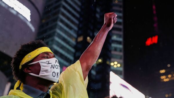 A demonstrator wearing a face mask raises his fist during a protest following the death of the Black man Daniel Prude, after police put a spit hood over his head during an arrest in Rochester on March 23, at Times Square in New York, U.S. September 3, 2020.  - Sputnik International