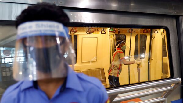 A worker wearing a face shield and mask cleans inside a train at a Delhi Metro station ahead of the restart of its operations, amidst the spread of coronavirus disease (COVID-19), in New Delhi, India, September 3, 2020. - Sputnik International