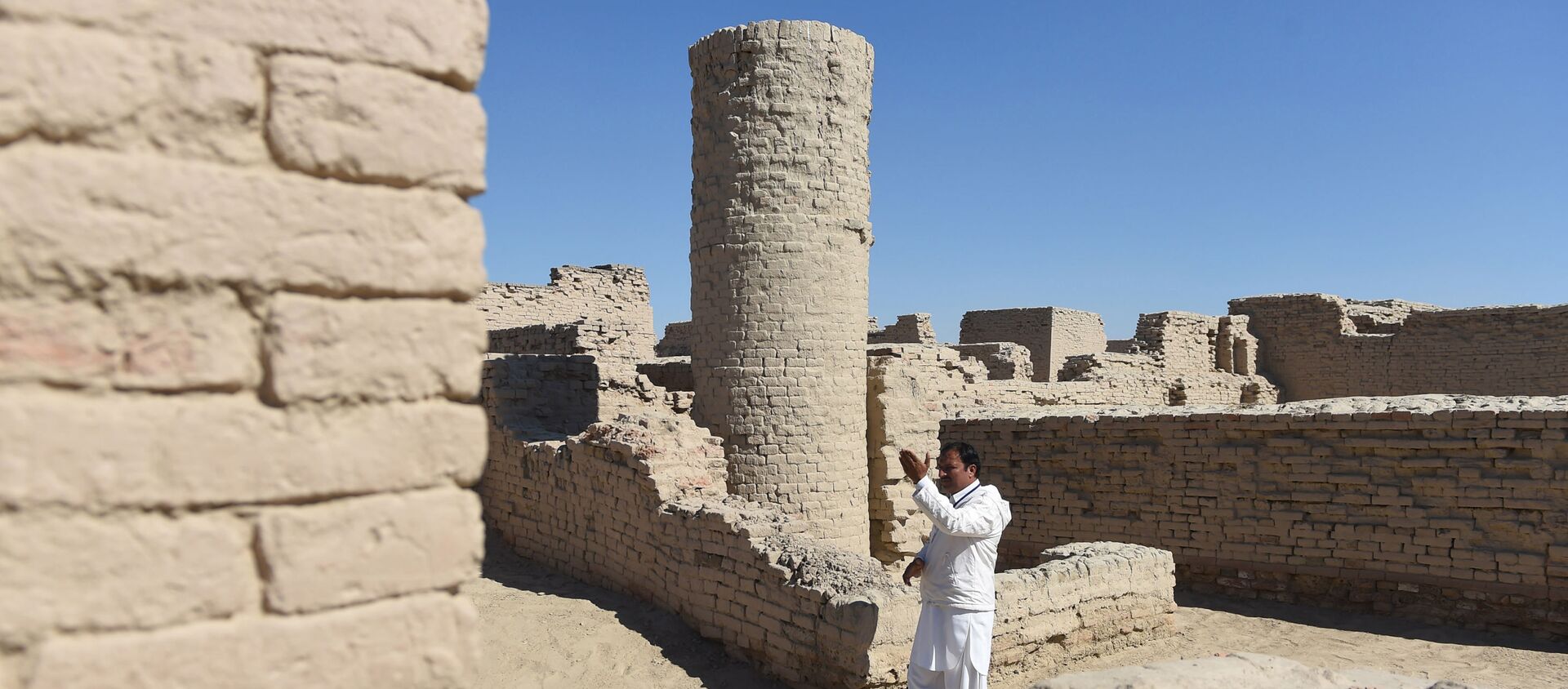 In this photograph taken on February 9, 2017, Pakistani caretaker at the UNESCO World Heritage archeological site of Mohenjo Daro, Ismail Mugheri, points out a two-story well at the site some 425 kms north of Karachi.  - Sputnik International, 1920, 05.09.2020
