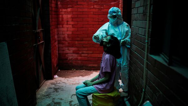 A health worker in personal protective equipment (PPE) collects a sample using a swab from a person at a local health centre to conduct tests for the coronavirus disease (COVID-19), amid the spread of the disease, in New Delhi, India, 31 August 2020.  - Sputnik International