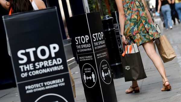 Shoppers walk past social distancing signs at the Covent Garden shopping and dining district, amid the spread of the coronavirus disease (COVID-19), in London, Britain, August 2, 2020 - Sputnik International