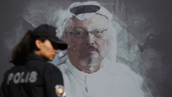 A Turkish police officer walks past a picture of slain Saudi journalist Jamal Khashoggi prior to a ceremony, near the Saudi Arabia consulate in Istanbul, marking the one-year anniversary of his death, Wednesday, Oct. 2, 2019 - Sputnik International