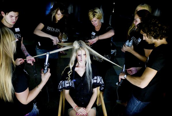 Several stylists prepare a model's hair backstage for the new Spring Summer 2008 collection by Danish designers Munthe Plus Simonsen during a fashion show at City Hall in Copenhagen, Denmark, Thursday, Aug. 9, 2007. - Sputnik International