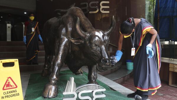 A woman cleans a bronze statue of a bull outside the Bombay Stock Exchange (BSE) in Mumbai, India, 12  June 2020 - Sputnik International