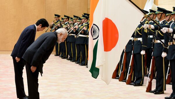 India's Prime Minister Narendra Modi (R) and his Japanese counterpart Shinzo Abe bow to national flags as they review an honor guard before their meeting at Abe's official residence in Tokyo on November 11, 2016 - Sputnik International
