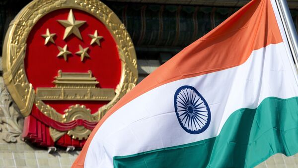 In this Oct. 23, 2013, file photo, an Indian national flag is flown next to the Chinese national emblem outside the Great Hall of the People in Beijing. China’s Commerce Ministry said Thursday, Aug. 13, 2020 it has extended punitive tariffs on Indian optical fiber products for five years. The announcement follows a yearlong review after a previous tariff expired in 2019 - Sputnik International