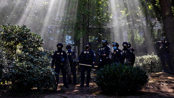 Portland Police officers observe as groups like the Proud Boys and Patriot Prayer faced off against protesters against systemic racism and police brutality in Portland, Oregon, 22 August 2020 - Sputnik International