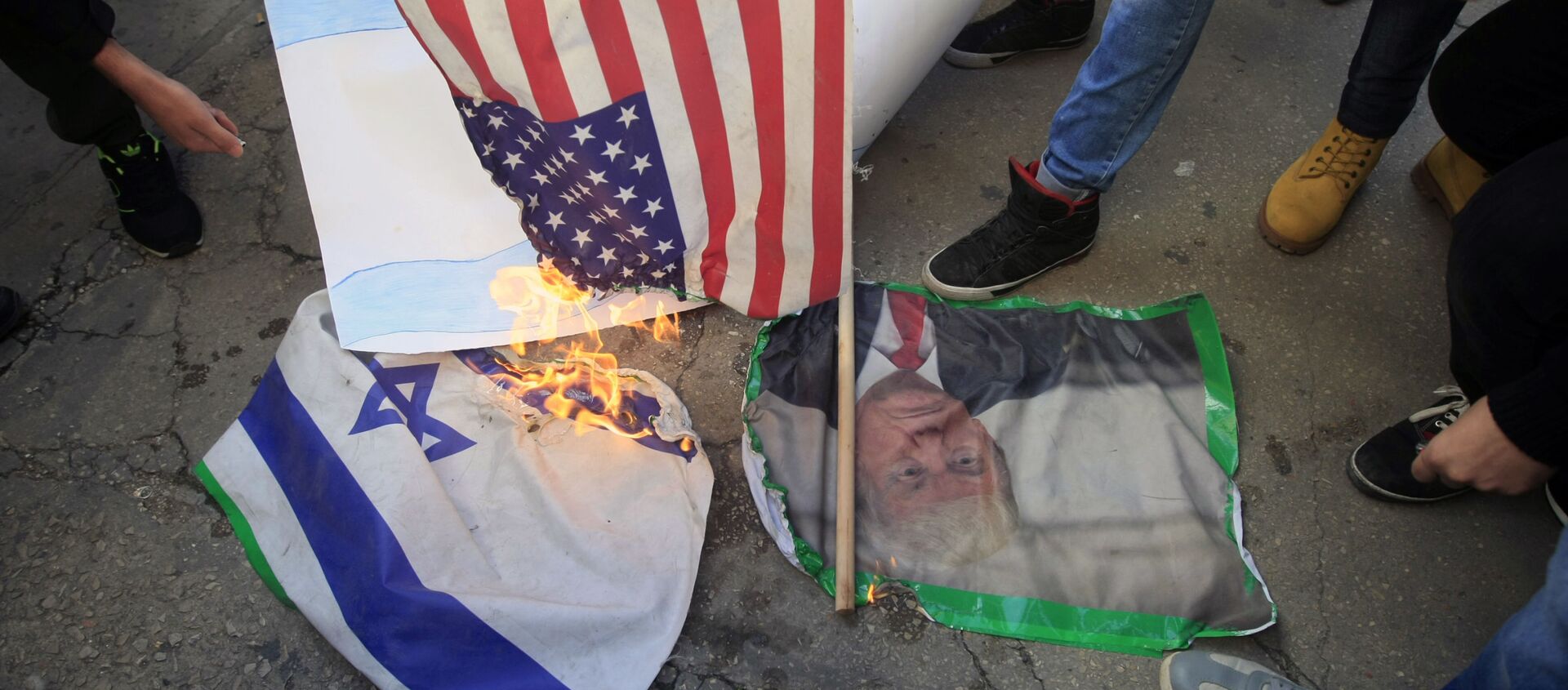 Lebanese and Palestinians students, burn a picture of U S. President Donald Trump, an American flag and an Israeli flag, as they take part in a protest at the Lebanese University, in the southern port city of Sidon, Lebanon, 7, December 2017, against U.S. President Donald Trump's decisions to recognise Jerusalem as the capital of Israel. - Sputnik International, 1920, 11.09.2020
