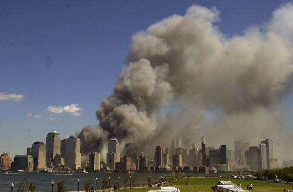 The World Trade Center is seen burning in New York City in this view from Liberty State Park in Jersey City, N.J., after the attacks on the towers and at the Pentagon in Washington - Sputnik International