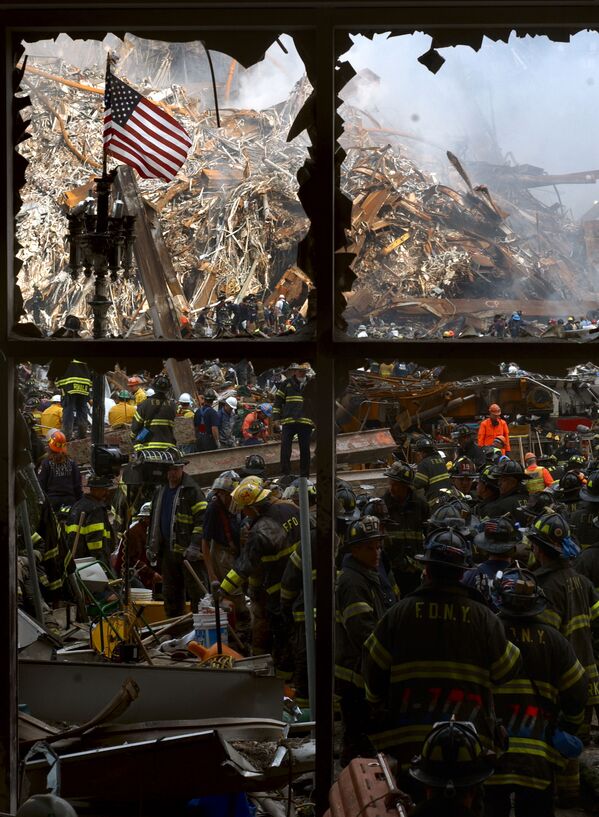 New York City firemen walk past the American flag as they work their way toward the heart of the devastation that was once the World Trade Center - Sputnik International