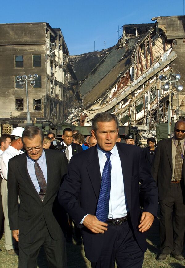 Then-US President George W. Bush (C) and then-US Secretary of Defence Donald Rumsfeld (L) tour the impact area (rear) at the Pentagon on 12 September 2001, where a hijacked airline was crashed into the building as part of a coordinated terrorist attack on the US - Sputnik International